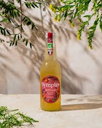 Bouteille de Symples infusion estivale, édition limitée, avec des agrumes et romarin sur un fond naturel.